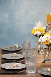 Photo of Elegant festive setting with floral decor on wooden table