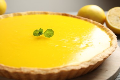 Delicious homemade lemon pie with mint on wooden board, closeup