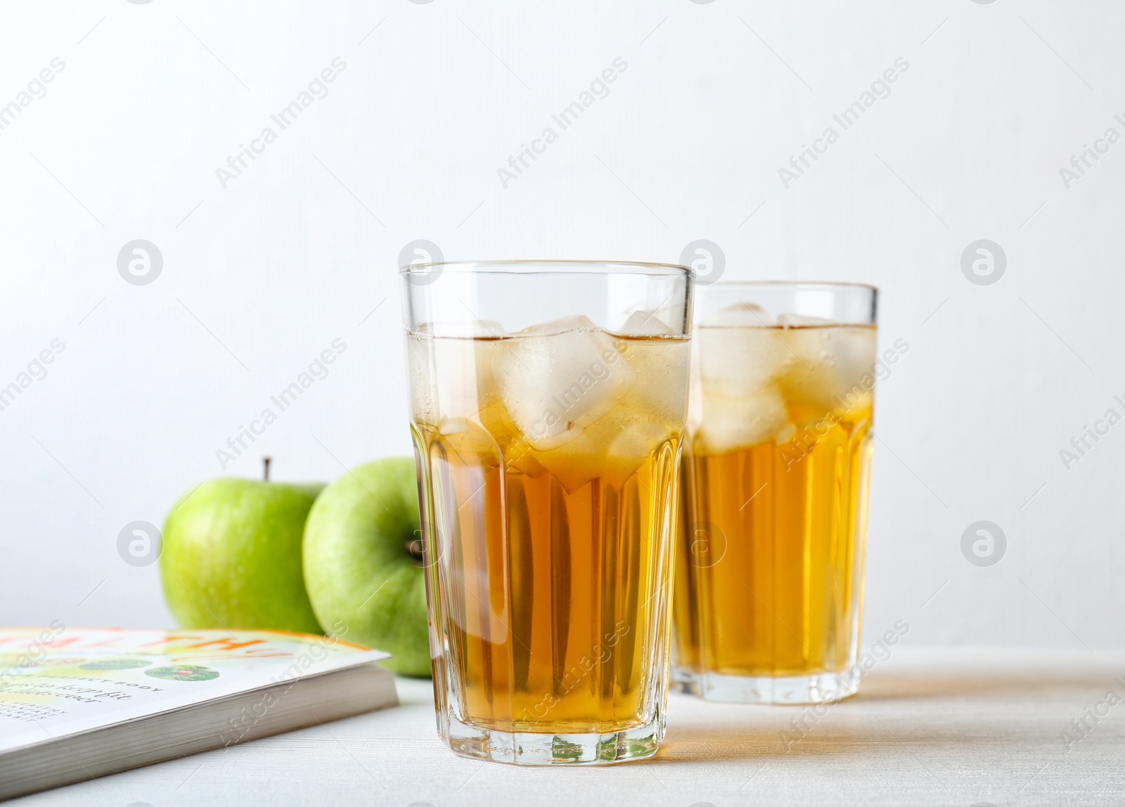 Photo of Two glasses of fresh apple juice on table