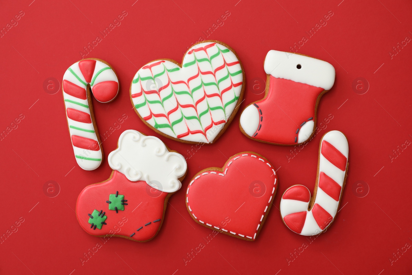 Photo of Different Christmas gingerbread cookies on red background, flat lay