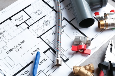 Professional plumber's supplies on house plan, closeup