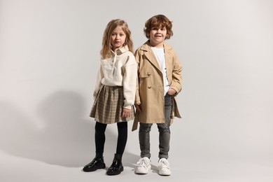 Photo of Fashion concept. Stylish children posing on light grey background