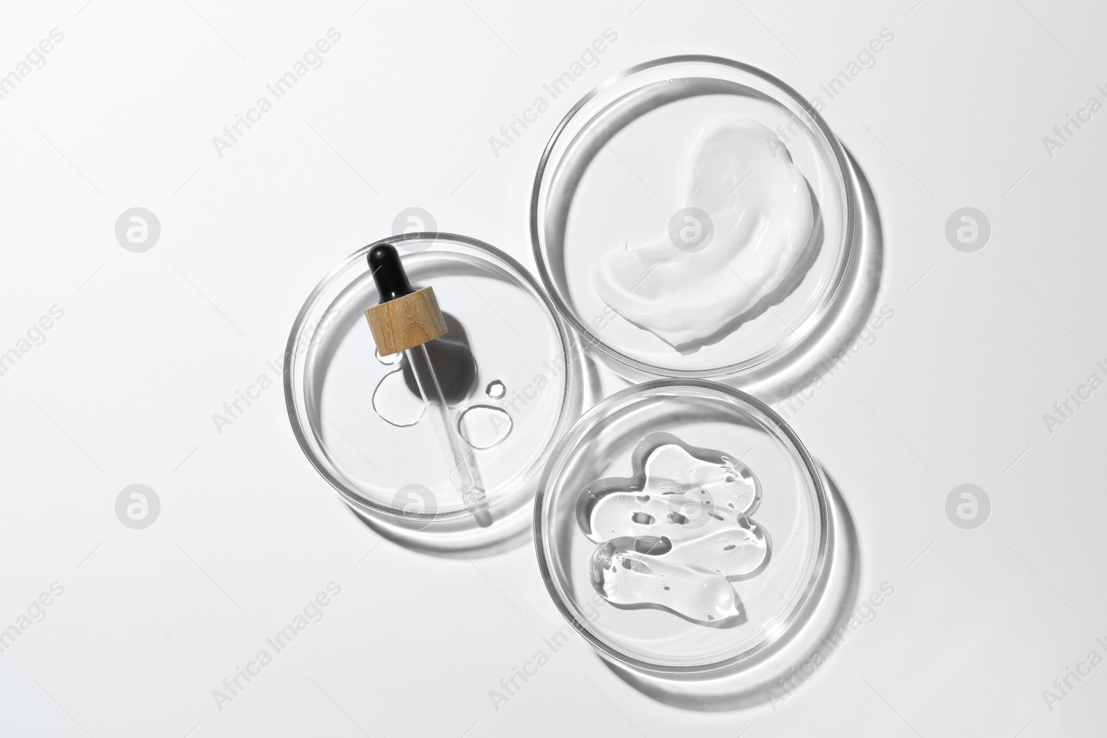 Photo of Many Petri dishes and cosmetic products on white background, top view