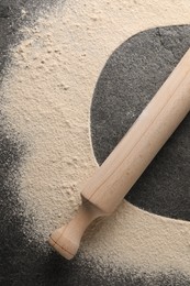 Photo of Imprint of board on grey textured table with flour and rolling pin, top view