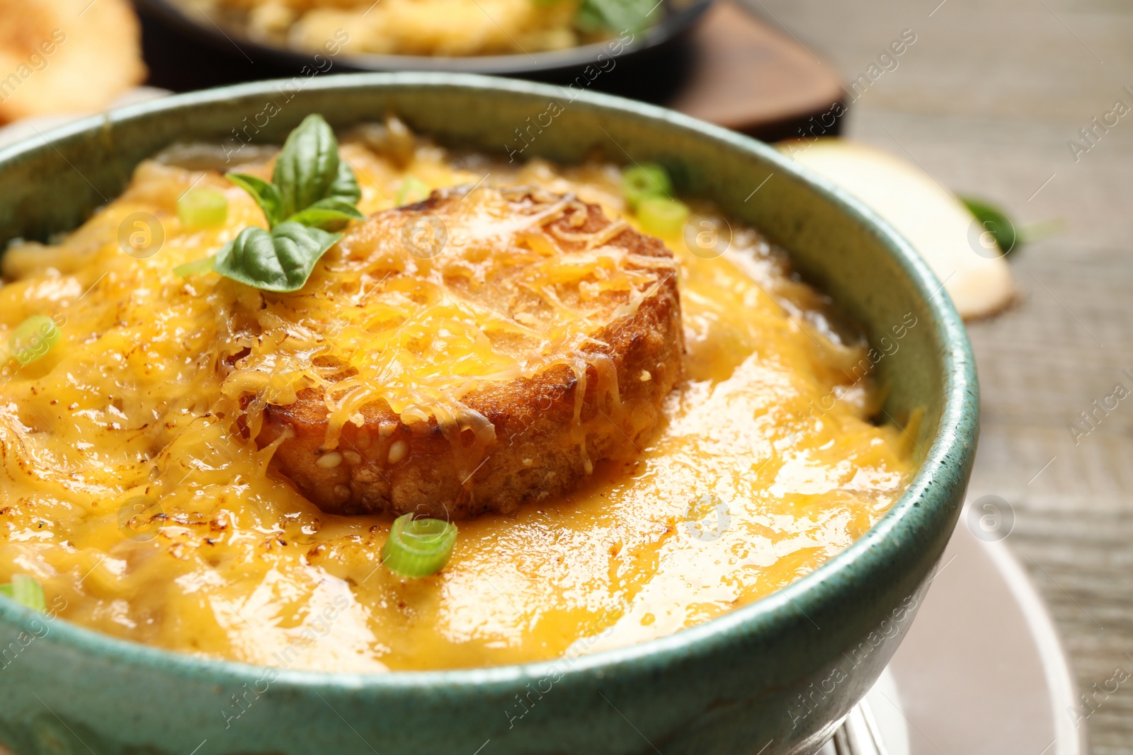 Photo of Tasty homemade French onion soup in bowl, closeup