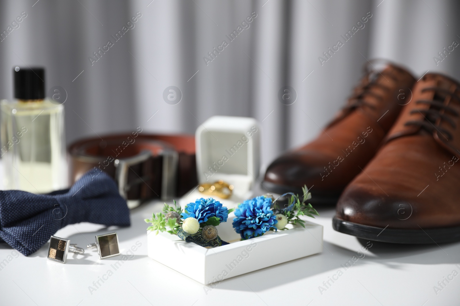 Photo of Wedding stuff. Composition with stylish boutonniere on white surface, closeup