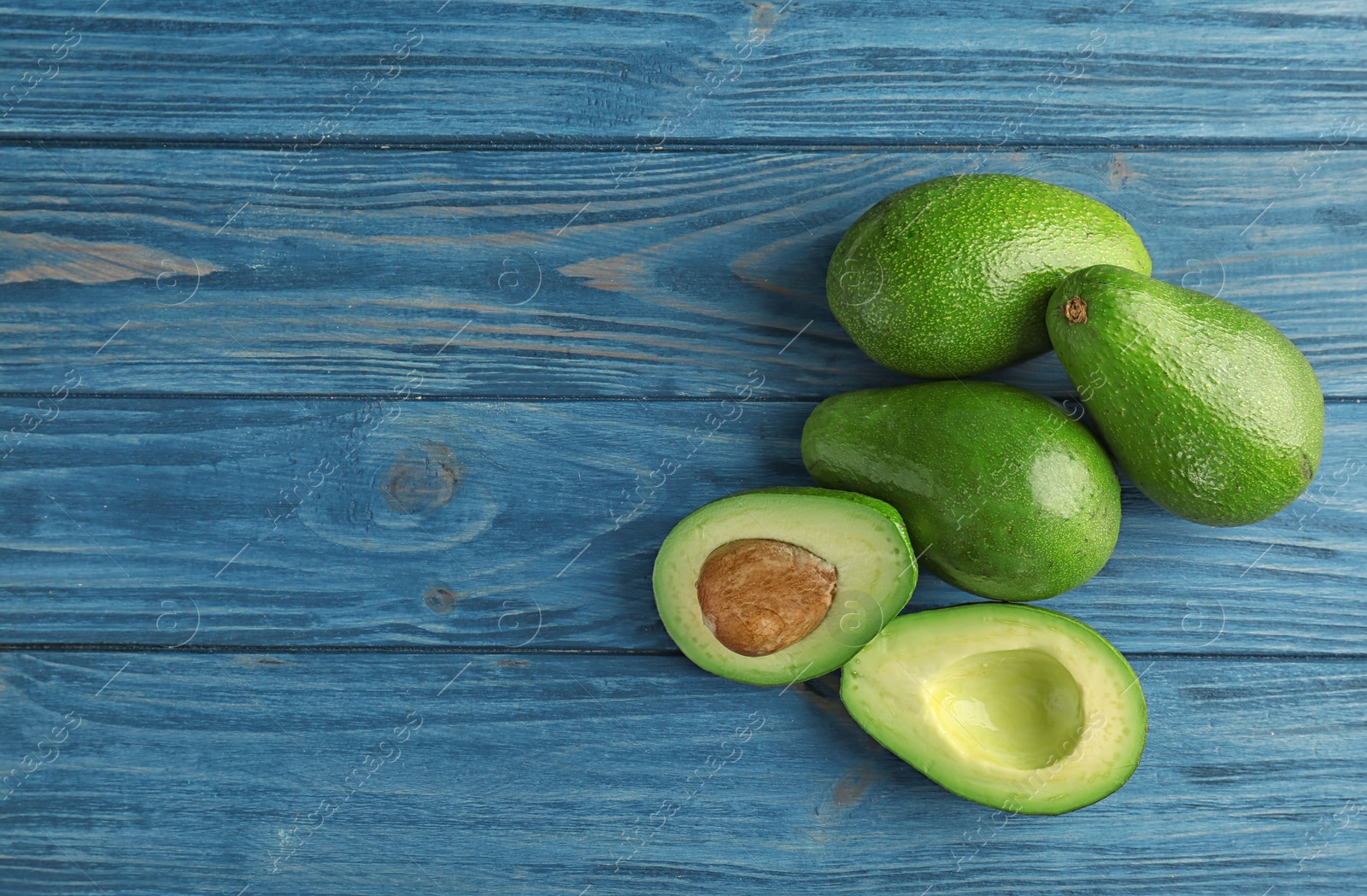 Photo of Tasty ripe green avocados on wooden background, top view