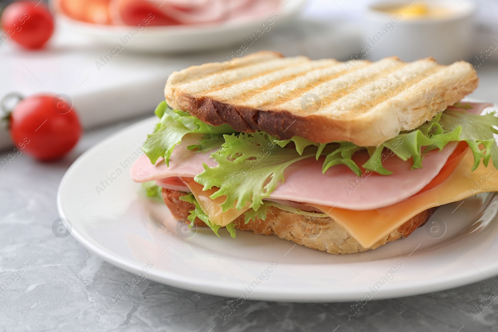 Photo of Tasty sandwich with ham on grey table, closeup