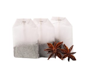 Photo of Tea bags and anise stars on white background