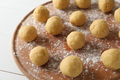 Shortcrust pastry. Raw dough balls on white wooden table, closeup