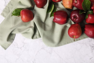 Photo of Fresh ripe red apples with leaves on white marble table, flat lay. Space for text