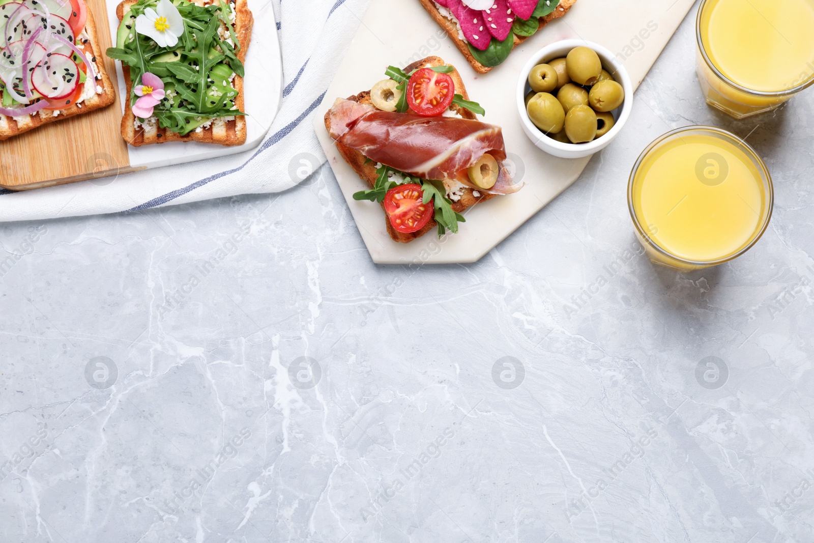 Photo of Different delicious sandwiches on light marble table, flat lay. Space for text