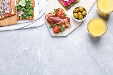 Different delicious sandwiches on light marble table, flat lay. Space for text