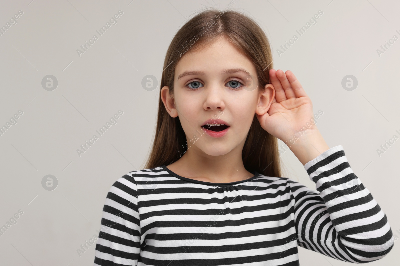 Photo of Little girl with hearing problem on grey background