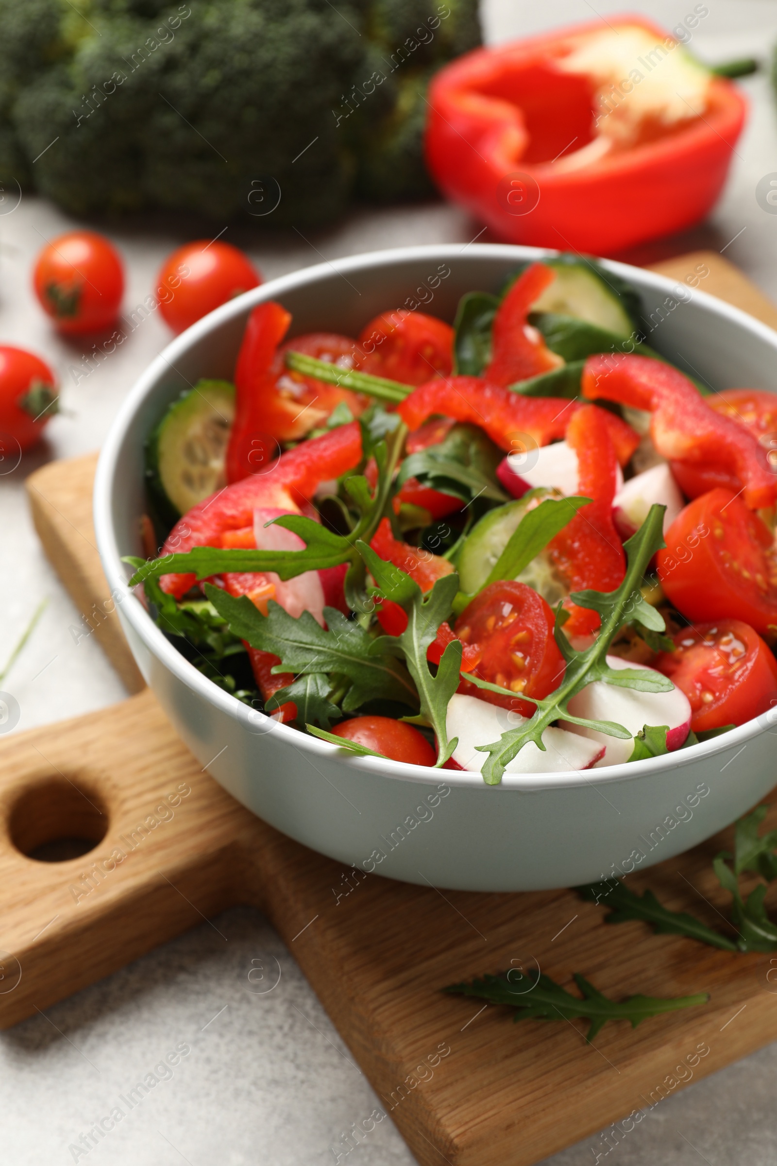 Photo of Tasty fresh vegetarian salad on light grey table, closeup