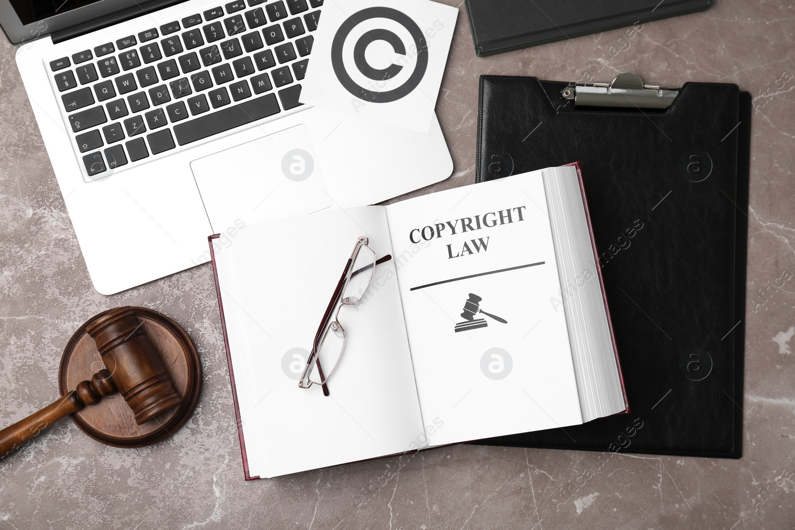 Photo of Flat lay composition with book, gavel and laptop on grey background. Copyright law concept