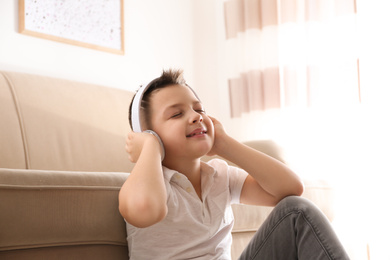 Photo of Little boy listening to music at home