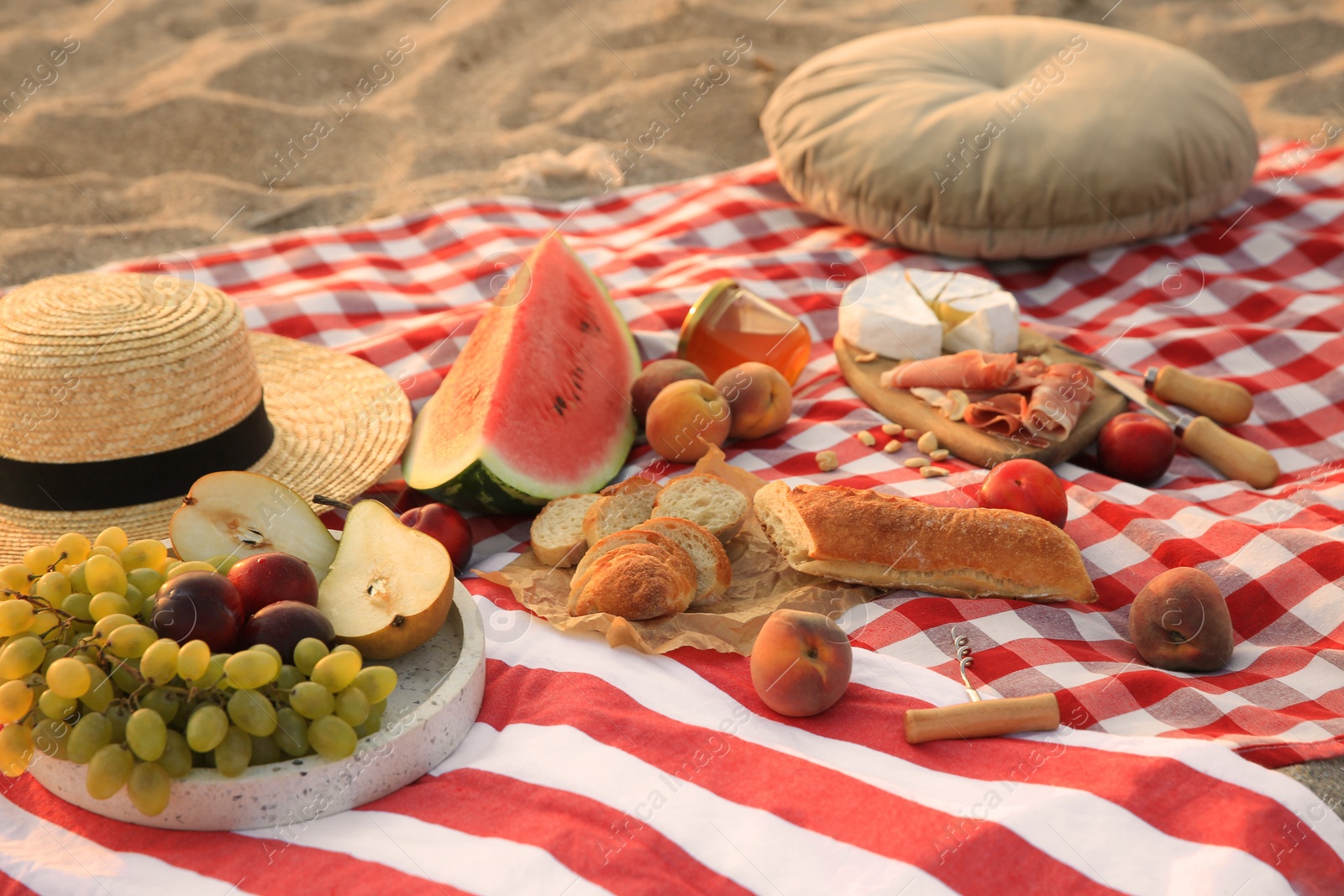 Photo of Different tasty snacks on picnic blanket outdoors