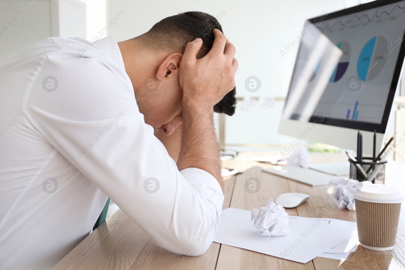 Photo of Businessman stressing out at workplace in office