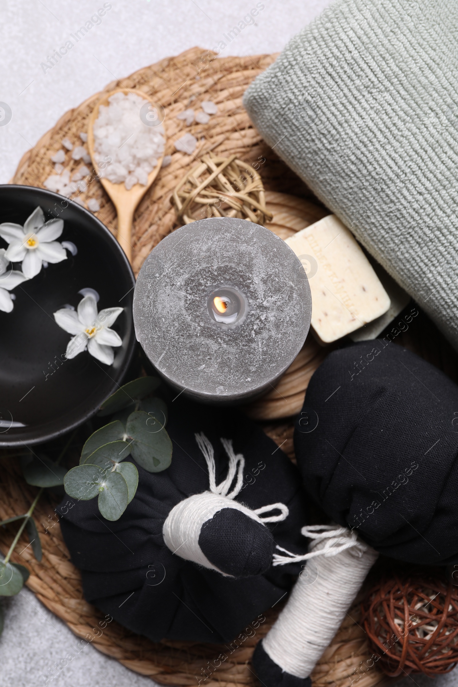 Photo of Flat lay composition with herbal massage bags, spa products and flowers on light grey table