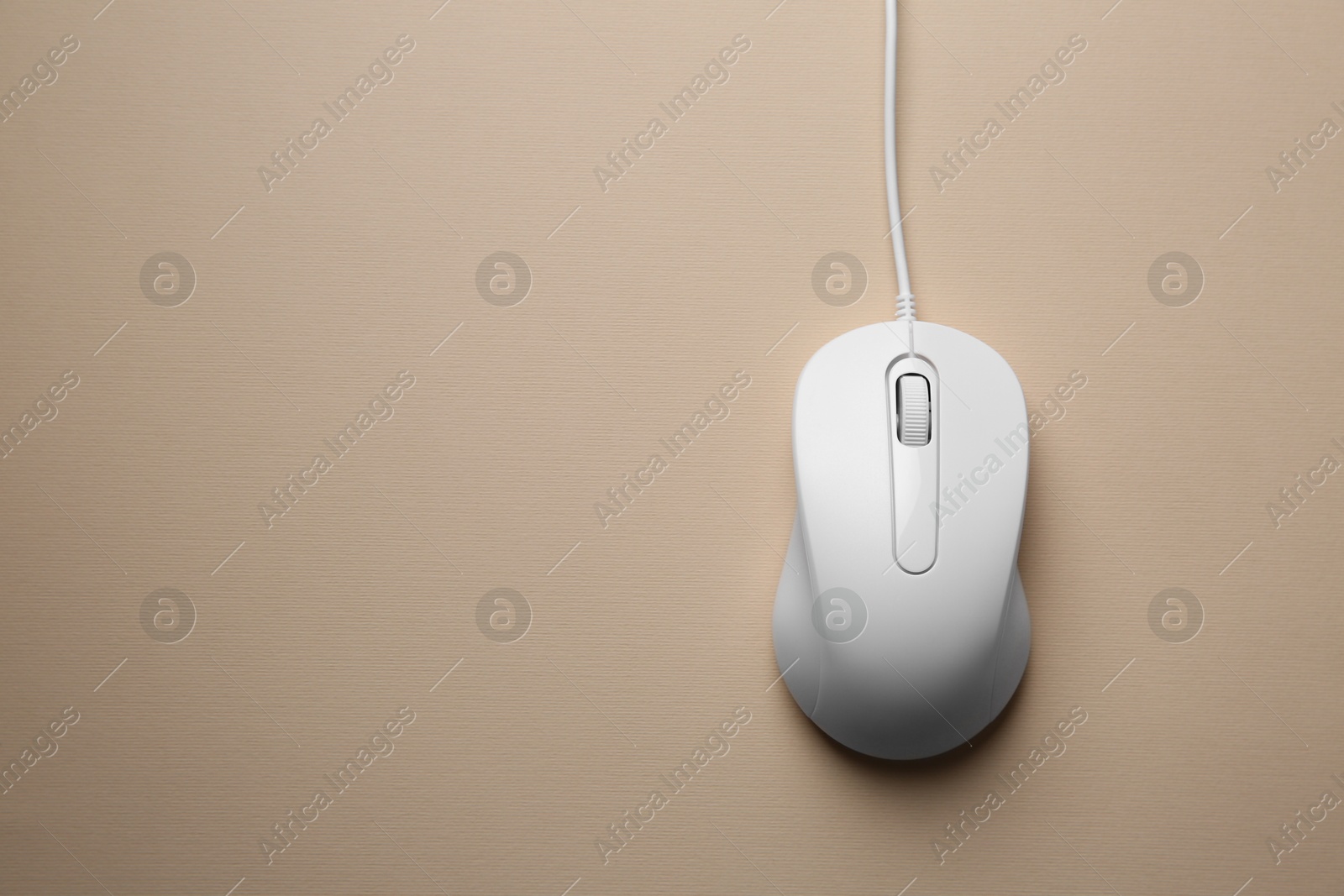 Photo of One wired mouse on beige background, top view. Space for text