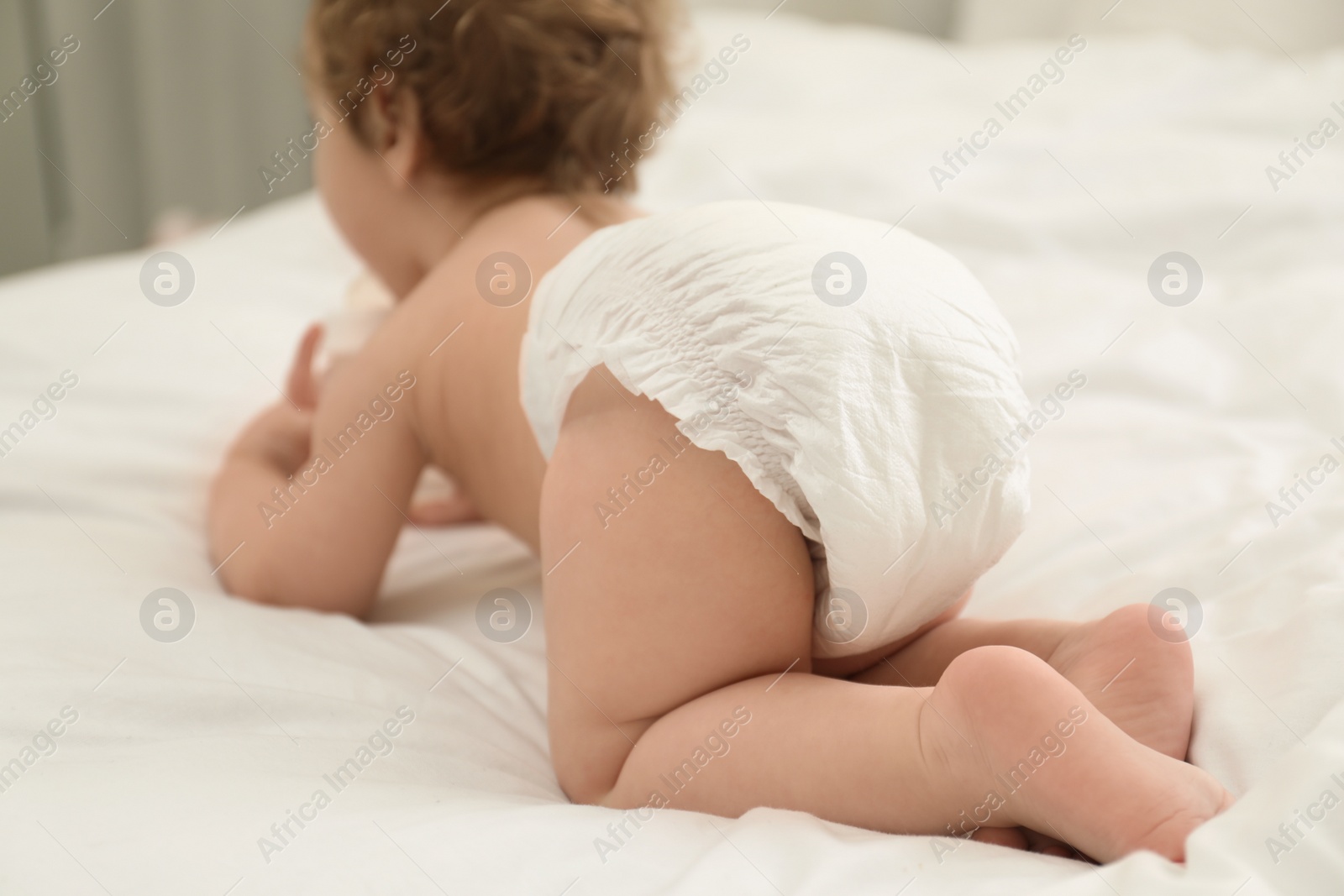 Photo of Cute little baby in diaper on bed