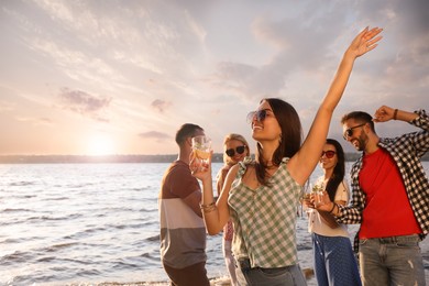 Photo of Woman with friends having fun near river at summer party