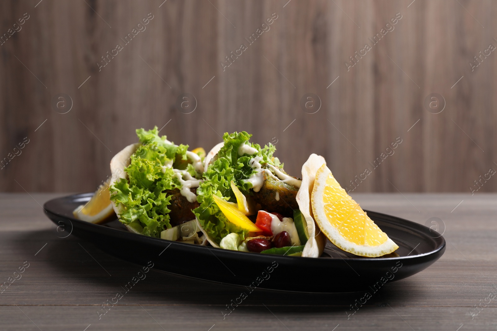 Photo of Delicious fresh vegan tacos served on wooden table