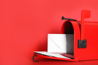 Photo of Open letter box with envelopes on red background. Space for text