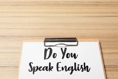 Photo of Clipboard with question Do You Speak English on wooden table, closeup. Space for text