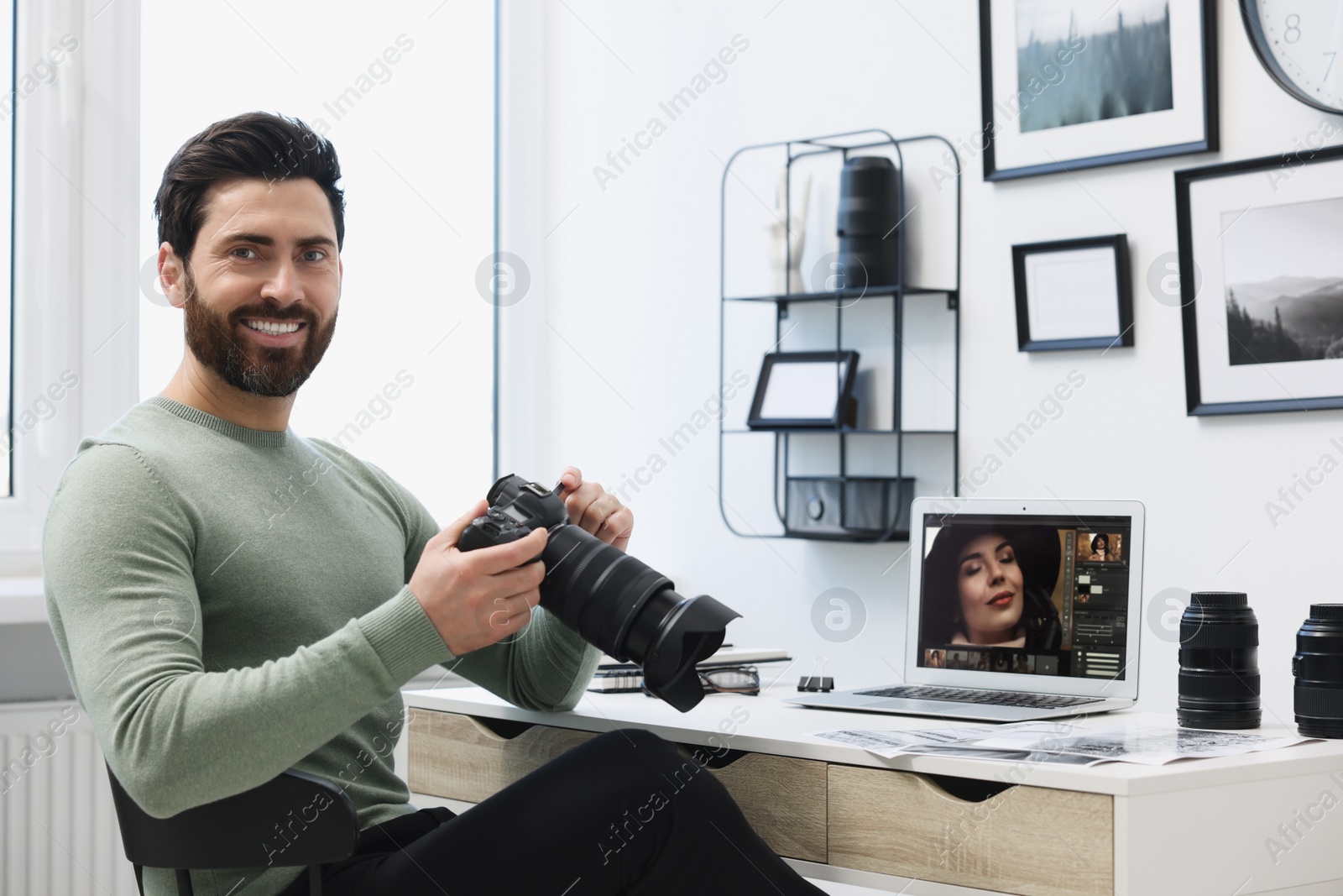 Photo of Professional photographer with digital camera at table in office