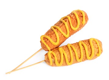 Delicious deep fried corn dogs with mustard on white background, top view