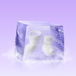 Image of Conservation of genetic material. Knitted baby booties in ice cube as cryopreservation on violet background