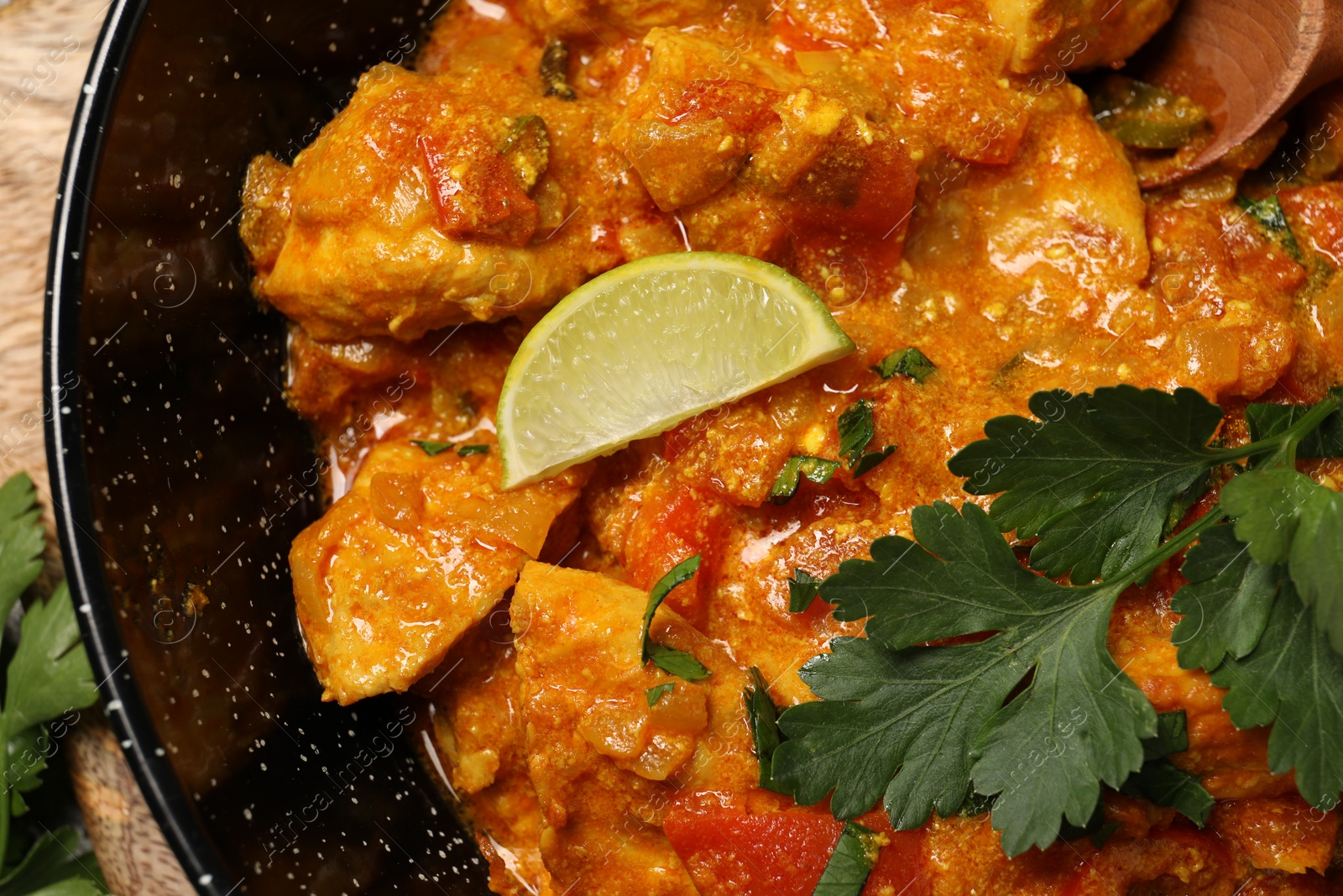 Photo of Delicious chicken curry in frying pan on table, top view