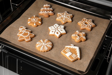 Photo of Baking tray with tasty Christmas cookies in oven