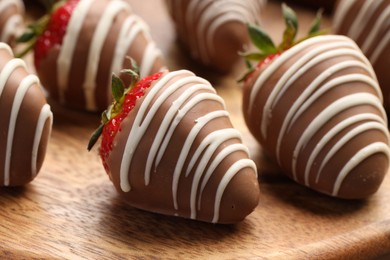 Photo of Delicious chocolate covered strawberries on wooden board, closeup