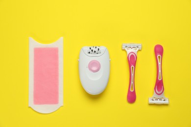Photo of Different epilation products on yellow background, flat lay