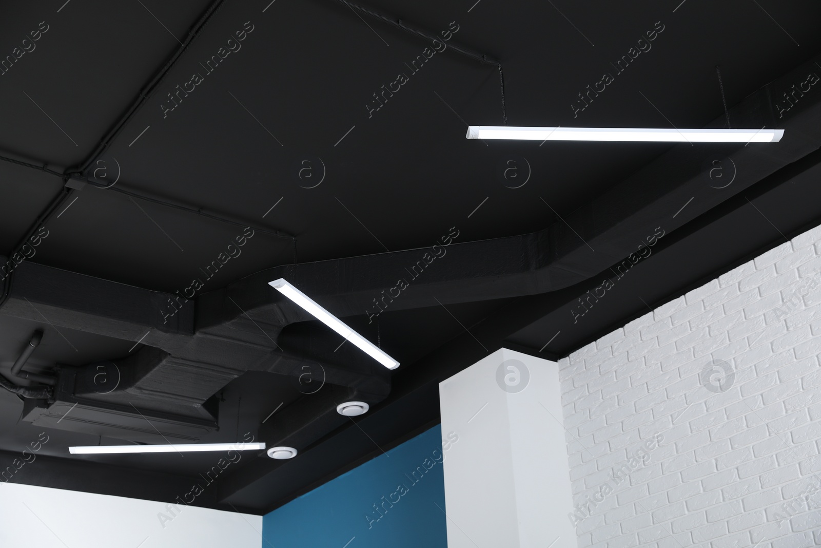 Photo of Black ceiling with modern lighting in room, low angle view