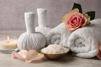 Photo of Composition with spa products, rose and candle on grey wooden table