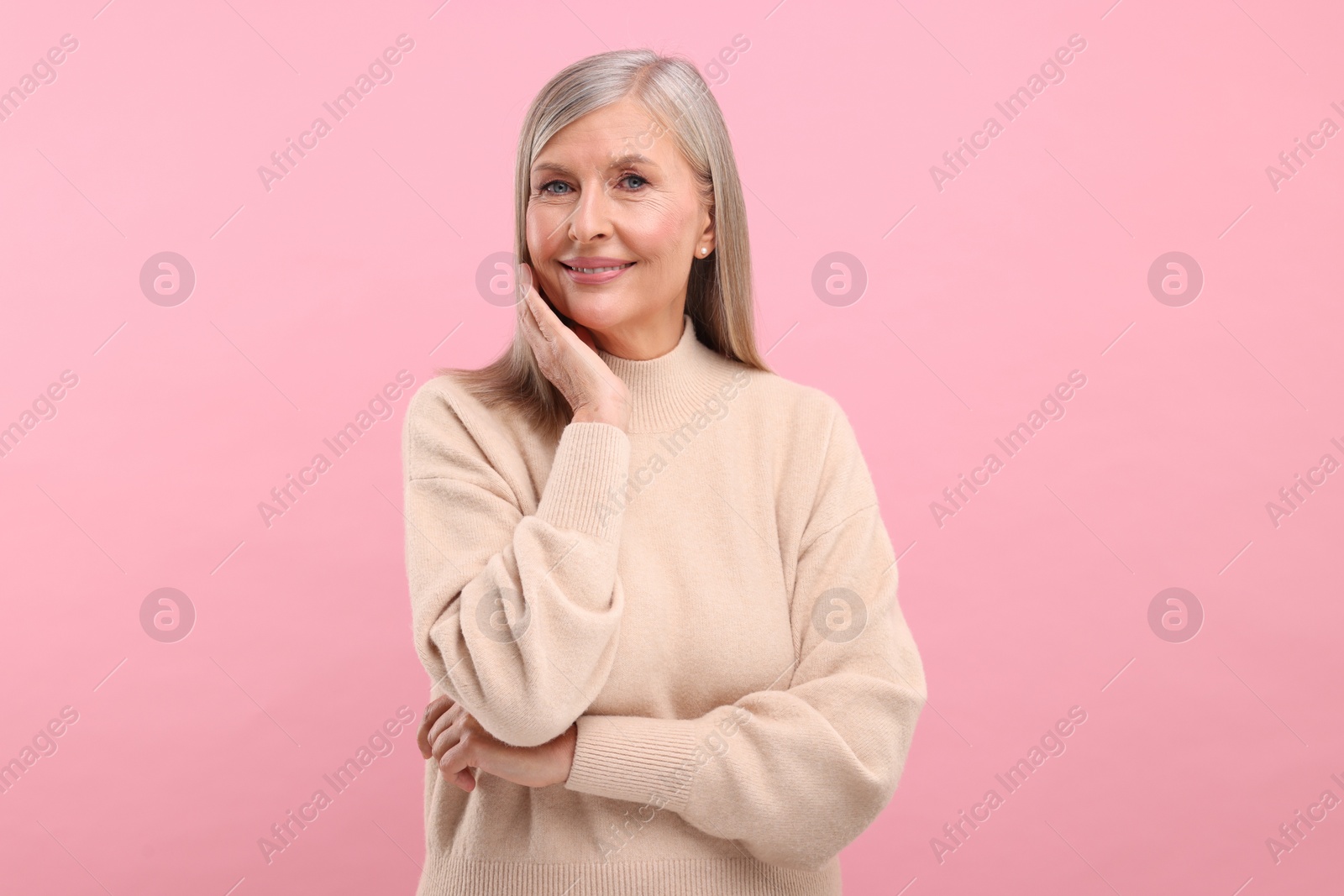 Photo of Portrait of beautiful middle aged woman on pink background