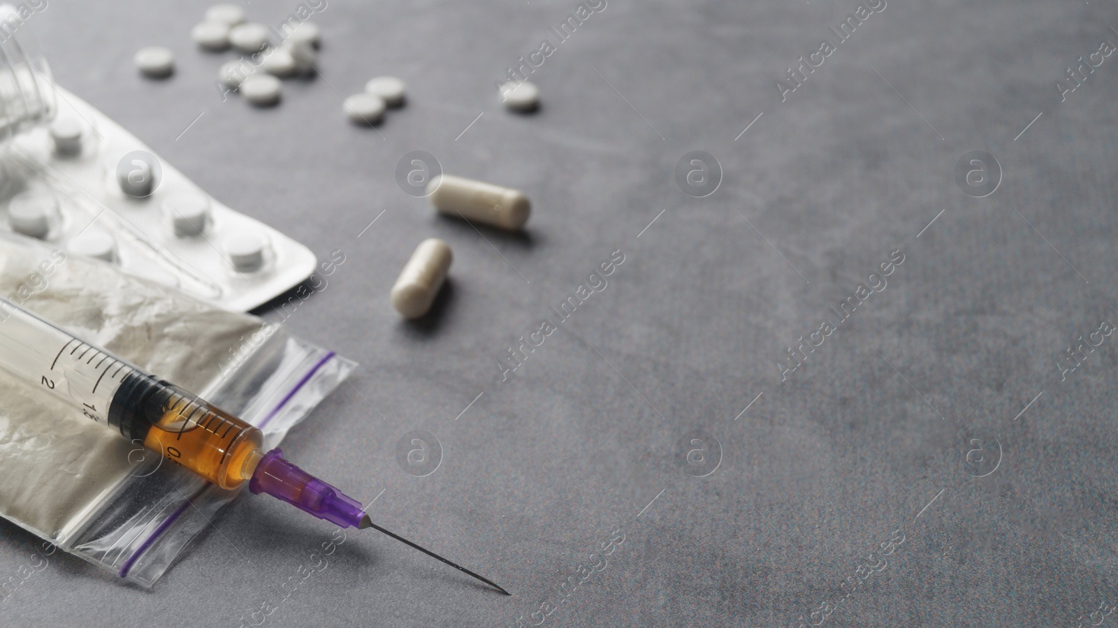 Photo of Different hard drugs on grey table, closeup. Space for text