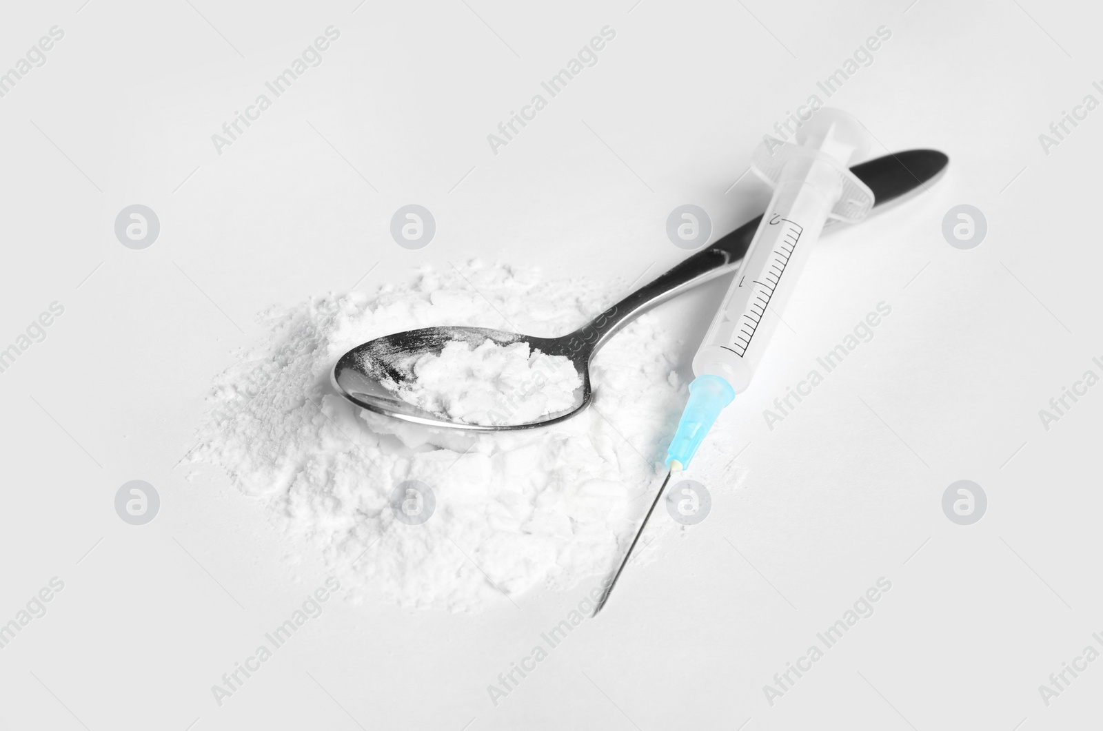 Photo of Spoon with cocaine and empty syringe on white background