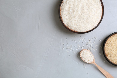 Flat lay composition with long grain and parboiled rice on grey background. Space for text