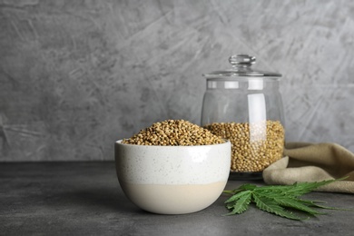 Bowl of hemp seeds on grey table