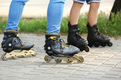 Photo of Father and son roller skating in park, closeup of legs