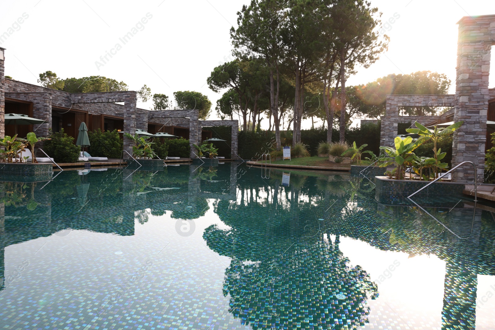 Photo of Outdoor swimming pool with umbrellas and sunbeds at resort