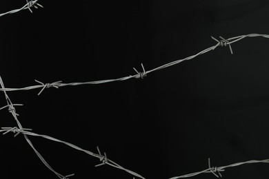 Photo of Shiny metal barbed wire on black background