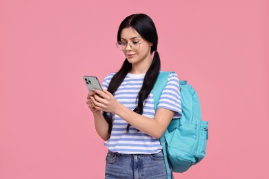 Photo of Student with smartphone and backpack on pink background