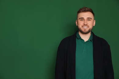 Photo of Portrait of young teacher on green background. Space for text