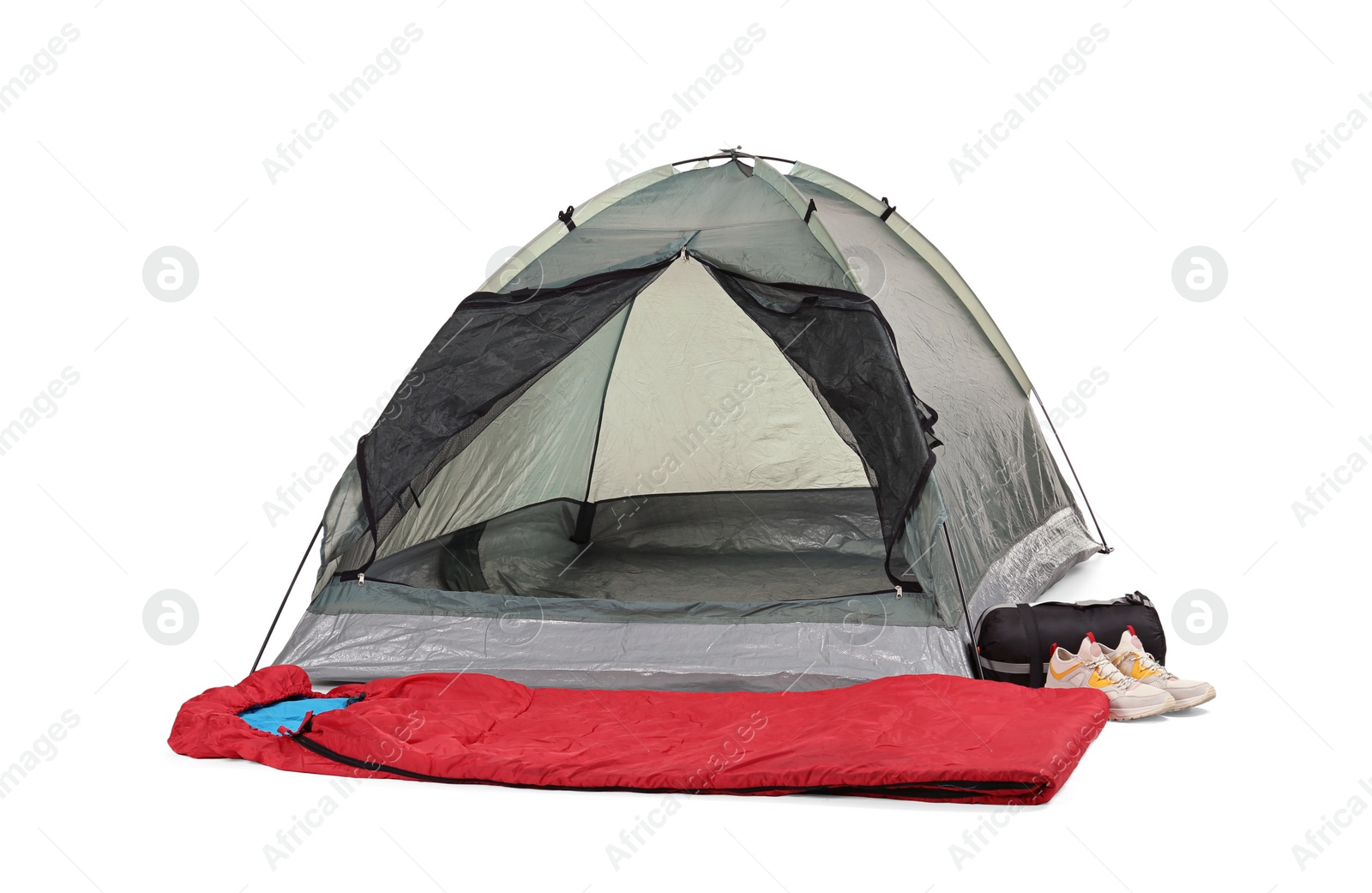 Photo of Comfortable grey camping tent with red sleeping bag and sneakers on white background